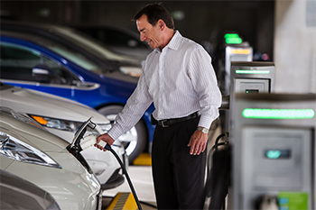 Man charging electric vehicle